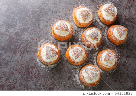 Scandinavian sweet buns stuffed with frangipane and whipped cream close-up. Horizontal top view Scandinavian sweet buns stuffed with frangipane and whipped cream close-up. Horizontal top view 94131922
