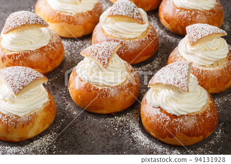 Scandinavian sweet buns stuffed with frangipane and whipped cream close-up. Horizontal 94131928