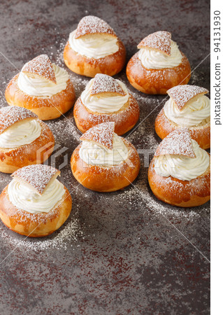 Semla vastlakukkel fastelavnsbolle fastlagsbull, Semlor, traditional scandinavian and estonian cardamom bun closeup. Vertical 94131930