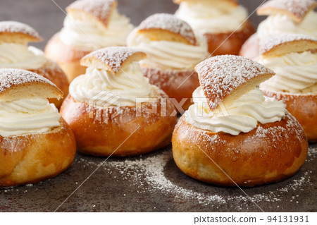 Semla Fastelavnsbolle Fastlagsbulle traditional scandinavian cream filled cardamom bun with almond paste closeup. Horizontal 94131931