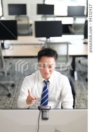 商人在空蕩蕩的辦公室進行視頻通話 94132417