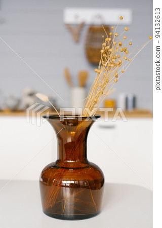 Brown glass vase with dried flowers in the interior of a modern house. Brown glass vase with dried flowers in the interior of a modern house. 94132613