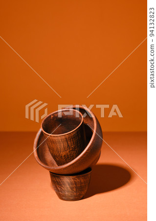 Composition with clay bowls on orange background Composition with clay bowls on orange background 94132823