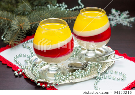 Christmas dessert jelly is a fruit berry raspberry and orange is served in portioned glasses. 94133216