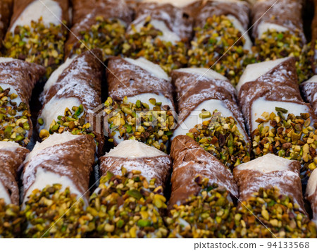 assortment of various Sicilian cannoli with chopped pistachios 94133568