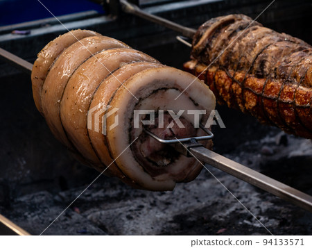 roast pork roll, Italian Porchetta, on red-hot embers roast pork roll, Italian Porchetta, on red-hot embers 94133571