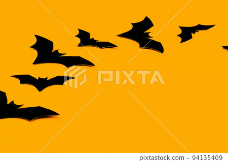 Two Black Bats on a Black Line on Orange Background as Halloween Background Two Black Bats on a Black Line on Orange Background as Halloween Background 94135409
