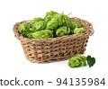 Hop cones in a straw basket on a white background. Green fresh hop cones for making beer and bread closeup. Hops are main ingredients in Beer production. 94135984