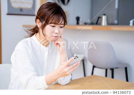 Young woman living room lifestyle smartphone 94136073