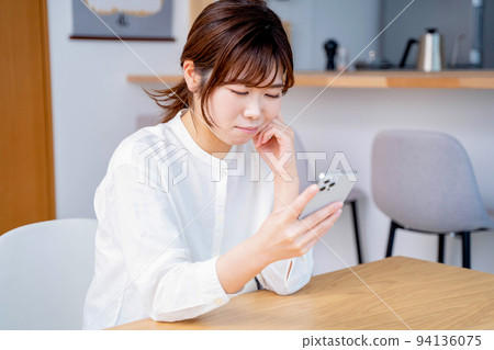 Young woman living room lifestyle smartphone 94136075