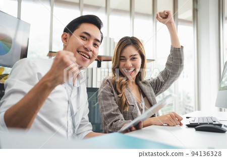 Excited young Asian startup business team celebrate successful and victory and hand up at office and looking at camera, happy euphoric proud Asian male and female professional winner feel overjoyed Excited young Asian startup business team celebrate successful and victory and hand up at office and looking at camera, happy euphoric proud Asian male and female professional winner feel overjoyed 94136328