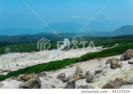 fumarole field on the slope of Mendeleev volcano on Kunashir island overlooking the ocean in the haze fumarole field on the slope of Mendeleev volcano on Kunashir island overlooking the ocean in the haze 94137204