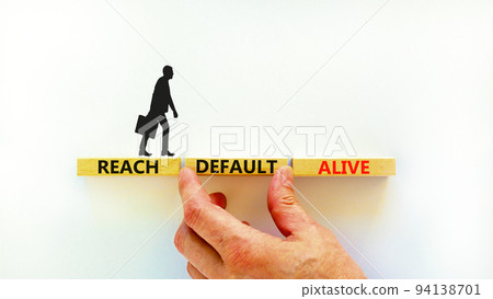 Reach default alive symbol. Concept words Reach default alive on wooden blocks on a beautiful white table white background. Businessman hand. Business, finacial and reach default alive concept. 94138701