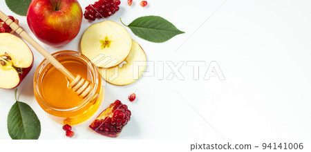 Happy Rosh Hashanah. Traditional Jewish holiday New Year. Apples, pomegranates and honey on white background. Banner format, place for text. 94141006