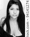 colorless portrait photo, latin woman with black hair and serious look, posing from front with white background 94141274