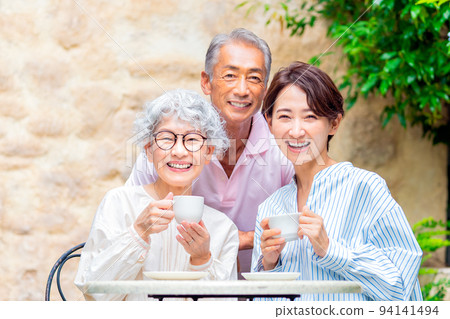 Parents and children having tea in the garden 94141494