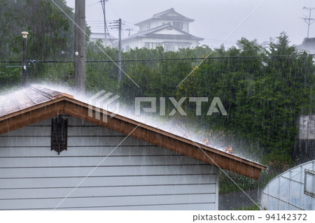 Heavy rain pouring down on a tin roof 94142372