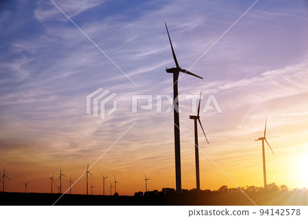 Beautiful sunset above the windmills on the field Beautiful sunset above the windmills on the field 94142578