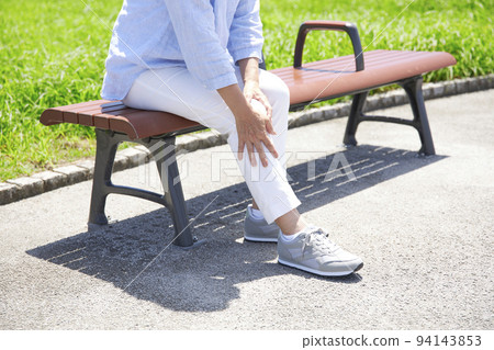 Middle-aged woman who feels knee pain while walking Middle-aged woman who feels knee pain while walking 94143853