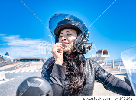 一位騎著大型巡洋艦自行車遊覽橫濱的女騎手在對講機上的對話 一位騎著大型巡洋艦自行車遊覽橫濱的女騎手在對講機上的對話 94145142