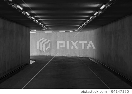 Road tunnel black and white, night illuminated, Urban tunnel without traffic, illuminated city highway tunnel with spotlights black and white. Road tunnel black and white, night illuminated, Urban tunnel without traffic, illuminated city highway tunnel with spotlights black and white. 94147350