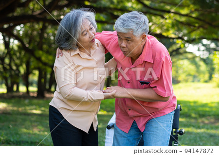 Asian senior man falling down on lying floor at park after Stumbled  and Crying in pain and him wife came to help support. Concept of old elderly insurance and health care 94147872