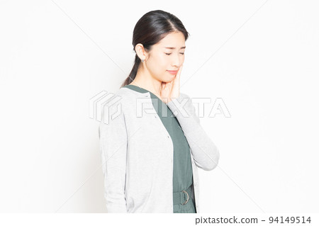 A woman who has a toothache and puts her hand on her cheek A woman who has a toothache and puts her hand on her cheek 94149514