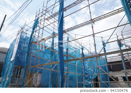 Single-family home under construction surrounded by scaffolding, home under repair, single-family home with exterior wall construction, blue sheet, Single-family home under construction surrounded by scaffolding, home under repair, single-family home with exterior wall construction, blue sheet, 94150476
