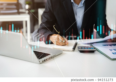 Businessman trading stocks online. Stock brokers looking at graphs, indexes and numbers on laptop and calculating on calculator. Business success concept. 94151273