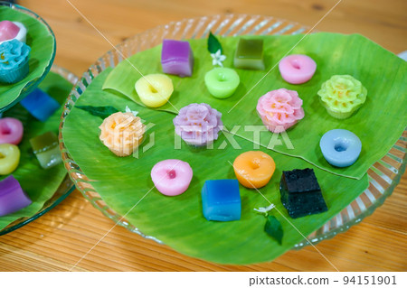 Varieties traditional colorful Thai desserts set; NamDokMai (steaming flour), PiekPoon (black custard), LeumKluen (coconut custard & steaming bean), KanomChan (layer pudding cake) 94151901