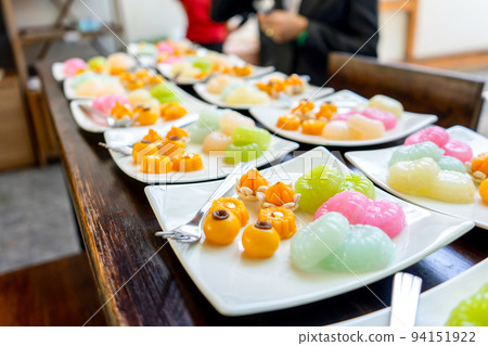 Traditional Golden and colorful Thai Dessert; JaMongKut, SaNayChan, ThongAek, MedKaNoon and Woon are set in seperated square white dish for serve to meeting member. 94151922