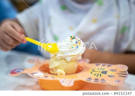 kid is eating ice-cream and whip cream in the icecream restaurant kid is eating ice-cream and whip cream in the icecream restaurant 94152147