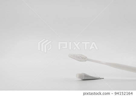Isolated simple and normal white toothbrush with small toothpaste on the white background in studio light. Isolated simple and normal white toothbrush with small toothpaste on the white background in studio light. 94152164