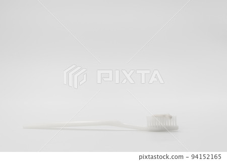 Isolated simple and normal white toothbrush with small toothpaste on the white background in studio light. Isolated simple and normal white toothbrush with small toothpaste on the white background in studio light. 94152165