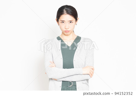 Angry woman standing in front of a white background Angry woman standing in front of a white background 94152352