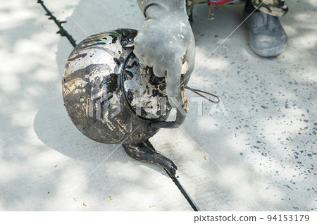 close up kettle asphalt in the worker rubber hand. 94153179