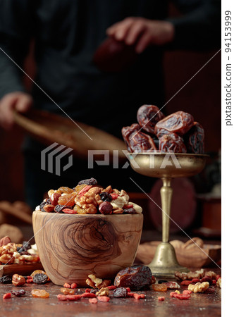 Various dried fruits and nuts on a kitchen table. Various dried fruits and nuts on a kitchen table. 94153999