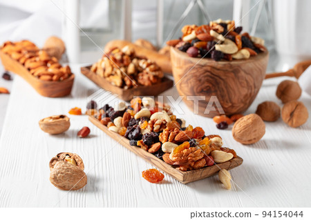 Mix of nuts and raisins on a white wooden table. Mix of nuts and raisins on a white wooden table. 94154044