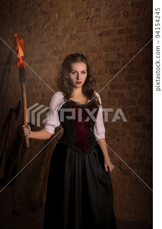 Fantastic medieval woman with a torch in her hands. Fantastic medieval woman with a torch in her hands. 94154245