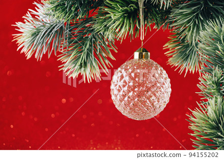 Christmas ornaments crystal bauble on green branch on red Christmas ornaments crystal bauble on green branch on red 94155202