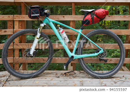 Turquoise bicycle on the background of a wooden fence. Turquoise bicycle on the background of a wooden fence. 94155597