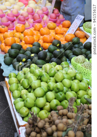Apples and other fruits sold at the open-air market. Most of them are imported. 94155617