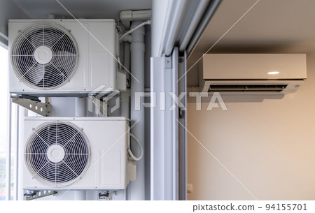 two air conditioning compressors are hung on wall. two air conditioning compressors are hung on wall. 94155701