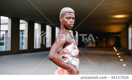 Confident black transsexual guy in dress looking at camera on street 94157026