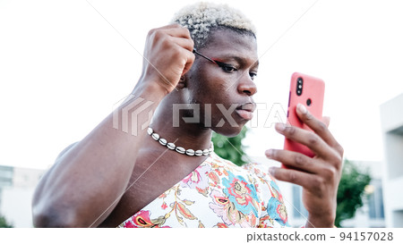 Non binary model applying makeup on street Non binary model applying makeup on street 94157028