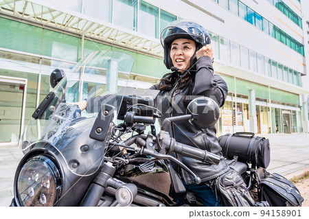 一位騎著大型巡洋艦自行車遊覽橫濱的女騎手,揮舞著拳頭 一位騎著大型巡洋艦自行車遊覽橫濱的女騎手,揮舞著拳頭 94158901