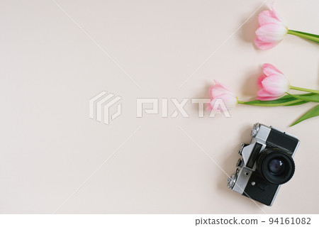 Photocamera retro and pink tulips on beige dark background. Template for advertising or visualization of blog with copy space, text place. Top view. The concept of spring Photocamera retro and pink tulips on beige dark background. Template for advertising or visualization of blog with copy space, text place. Top view. The concept of spring 94161082