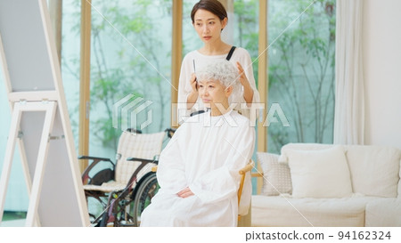 Visiting hairdresser and senior woman with gray hair Visiting hairdresser and senior woman with gray hair 94162324
