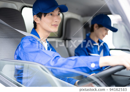 Young carrier male employee driving truck in uniform 94162583