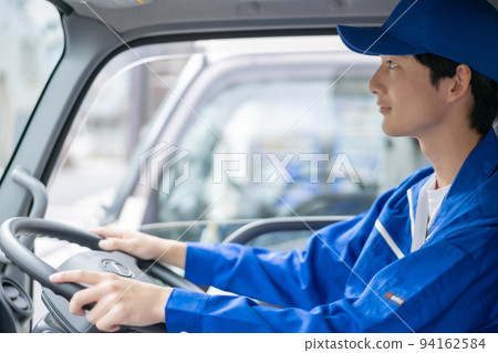 Young male carrier driving a truck 94162584